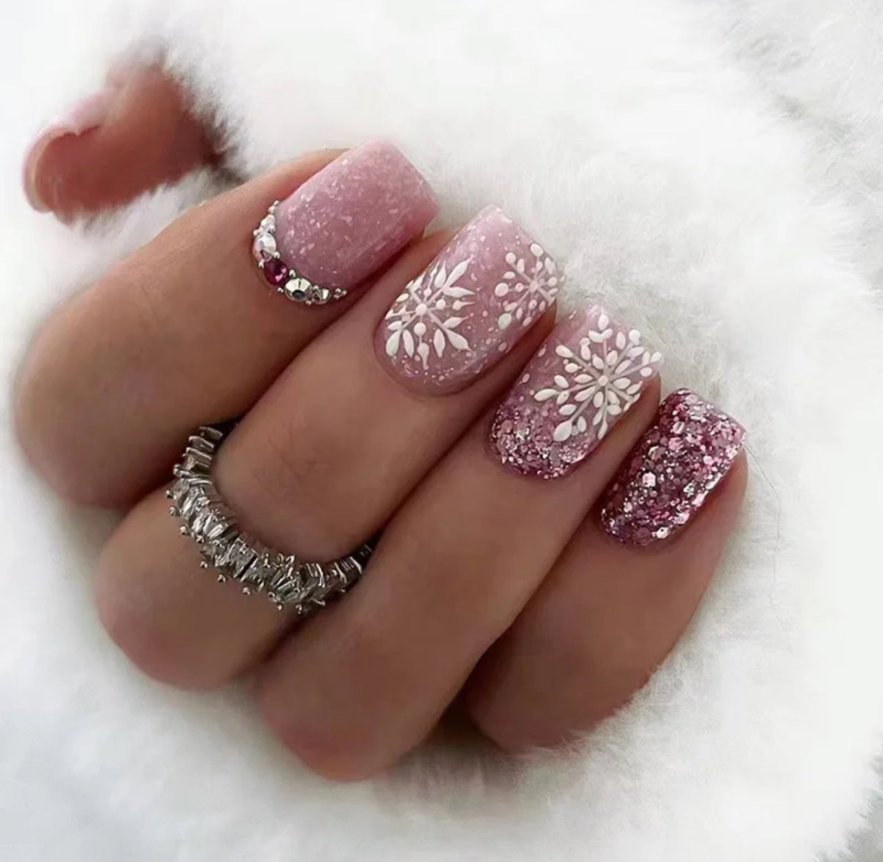 Féérie Hivernale - Faux-ongles roses avec des motifs de flocons de neige.