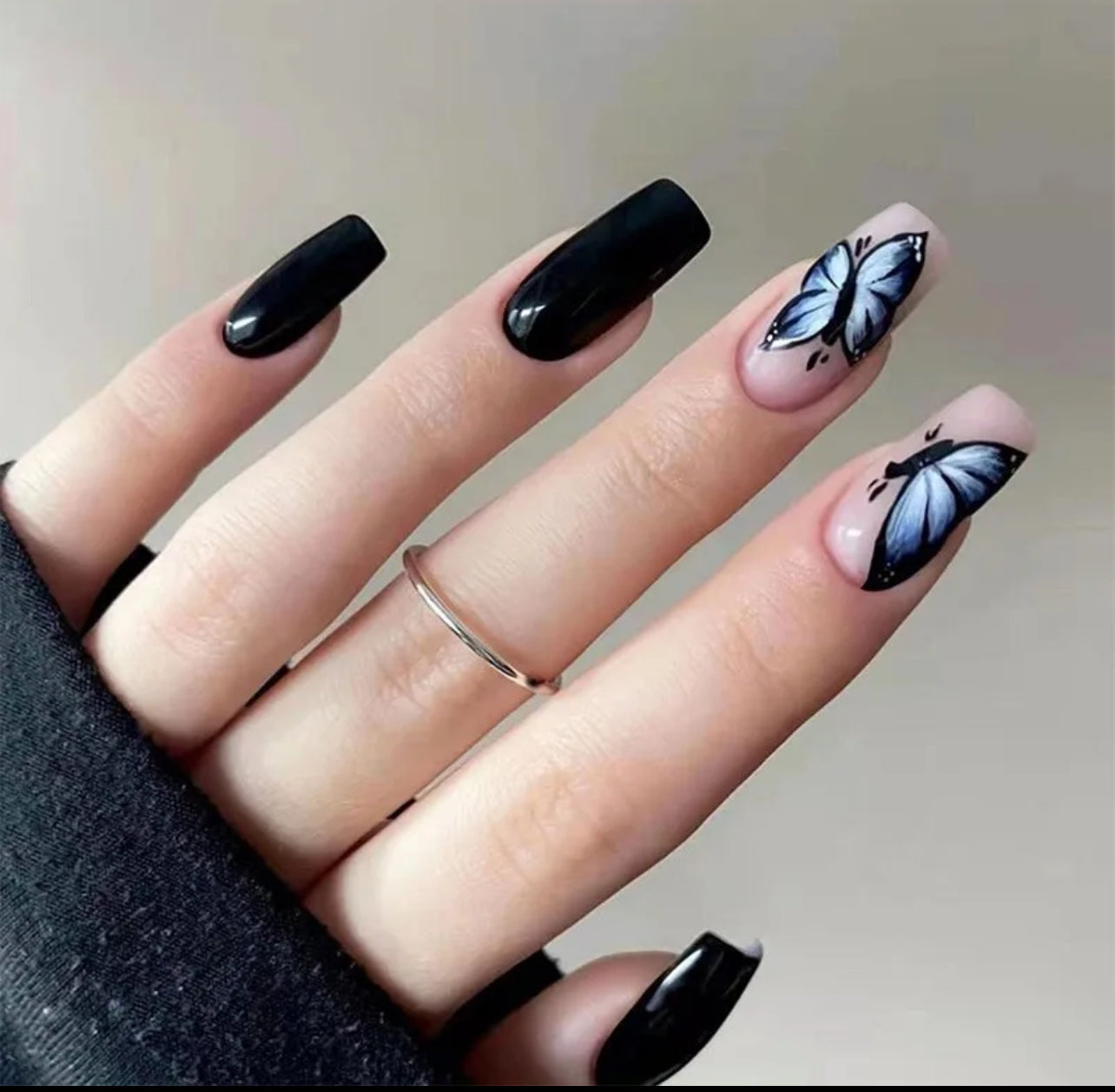 Élégance Nocturne - ongles noirs avec des papillons bleus.