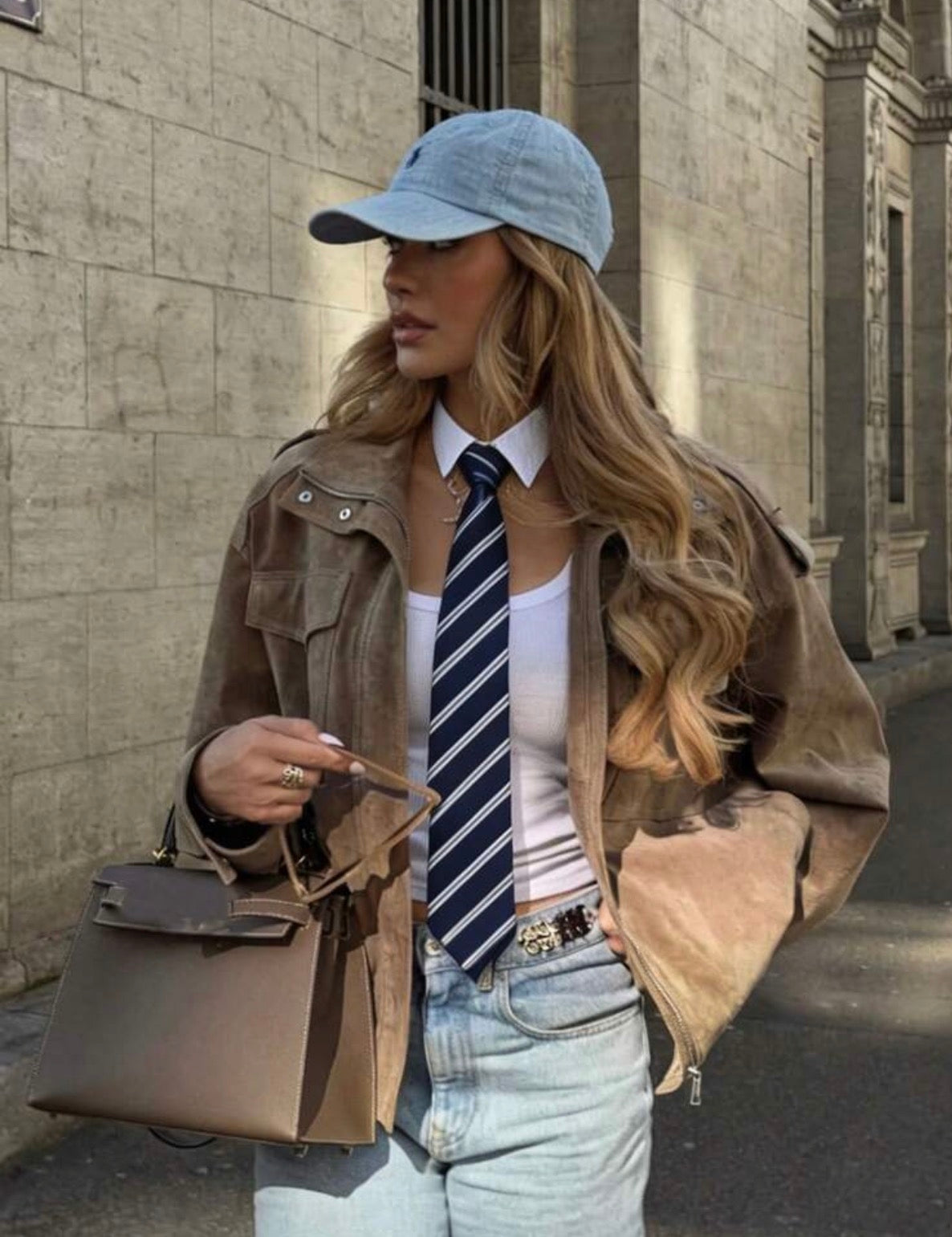 Cravate bleu marine rayée portée avec chemise blanche et veste marron