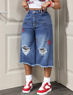 Jean bermuda femme en denim bleu avec poches décoratives et genoux déchirés