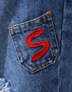 Détail broderie rouge sur poche du jean bermuda femme en denim bleu