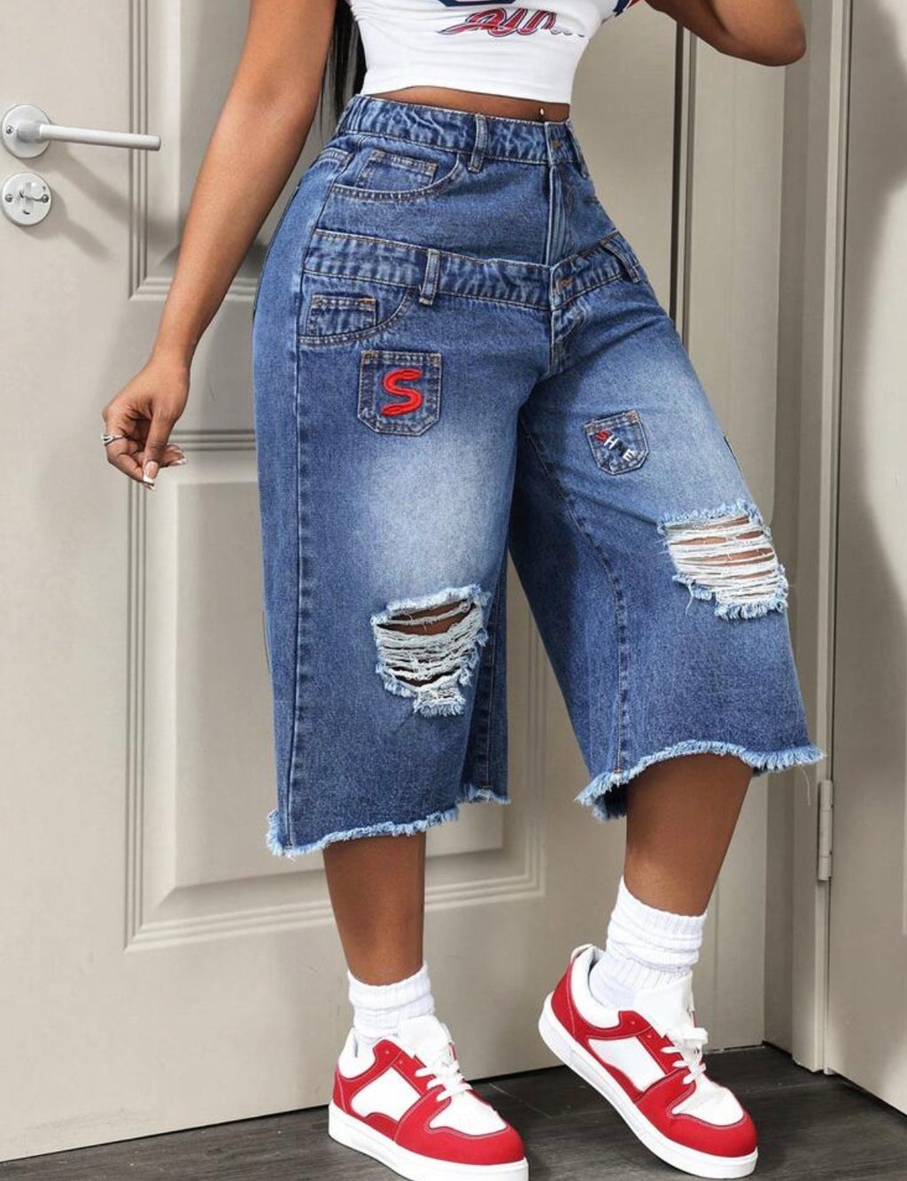 Jean bermuda femme en denim bleu coupe large, taille haute et ourlet effiloché