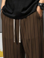 Détail pantalon large rayé marron taille élastique et cordon