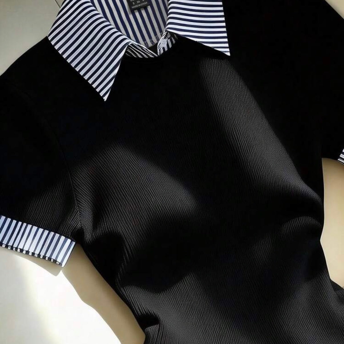 Détail de la robe polo noire rayée