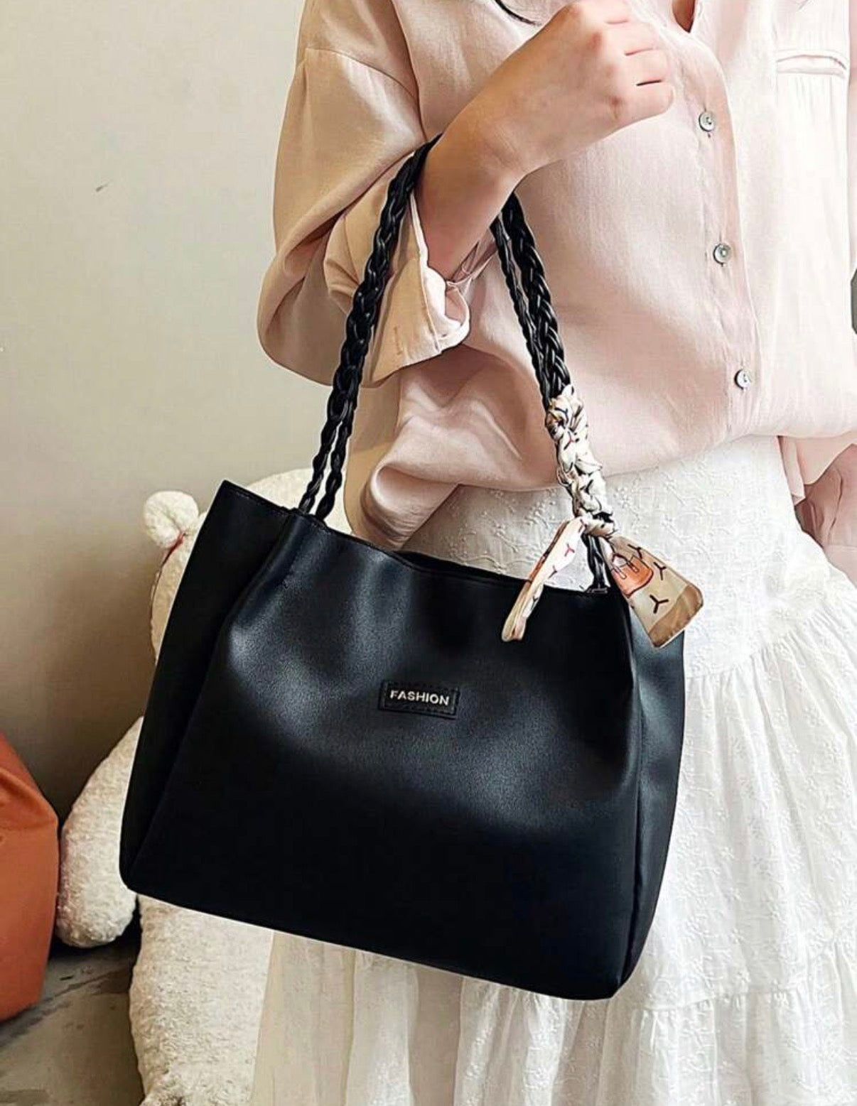 Sac cabas noir porté à l'épaule avec poignées tressées